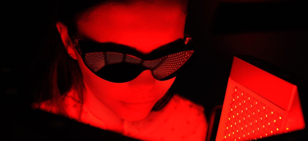 red light therapy. The girl goes through a course of skin rejuvenation with the help of red light treatment.