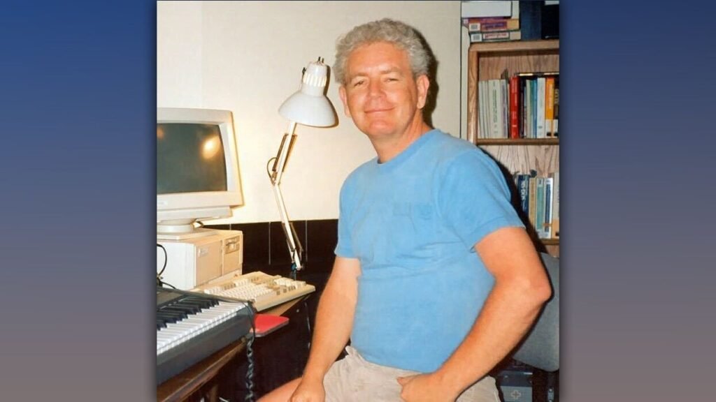 Bobby Prince sits in front of a PC, smiling for the camera.